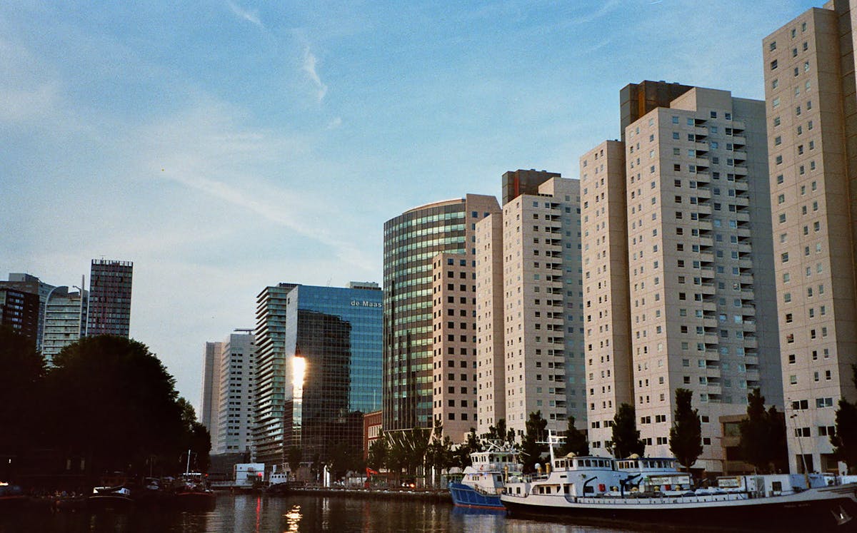 Rotterdam urban skyline under a clear blue sky with modern architecture and waterways
