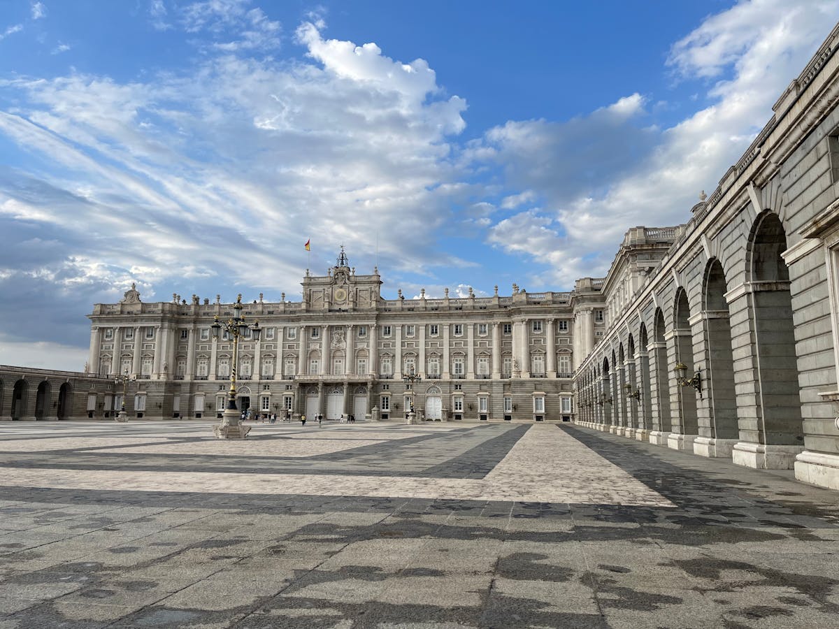The Royal Palace of Madrid against a dramatic sky