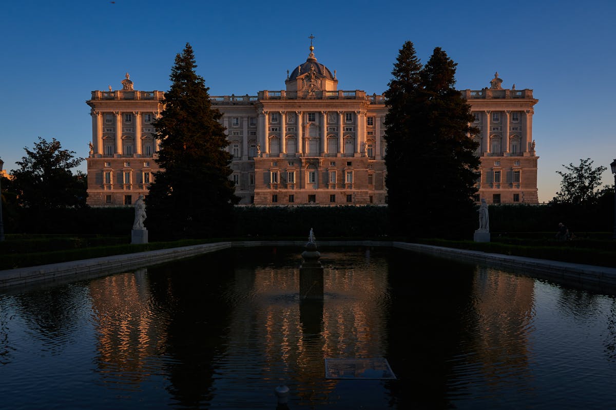 The Royal Palace of Madrid reflected in the pool of the Sabatini Gardens at twilight