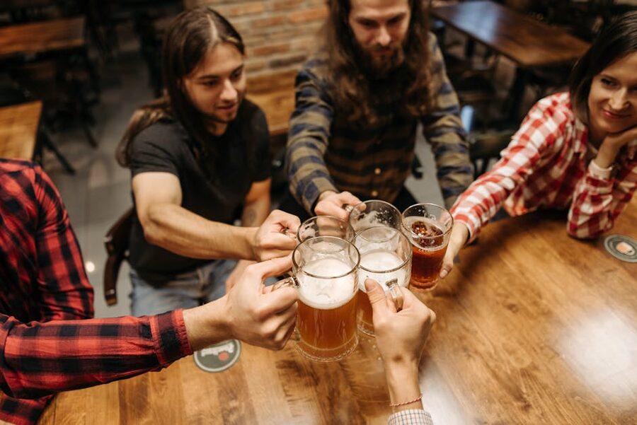 Friends clinking beer mugs cheers at a Budapest pub