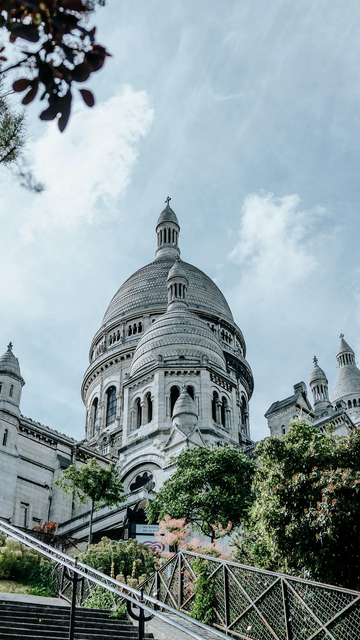 Sacre-Coeur Basilica under a clear blue sky with trees in foreground