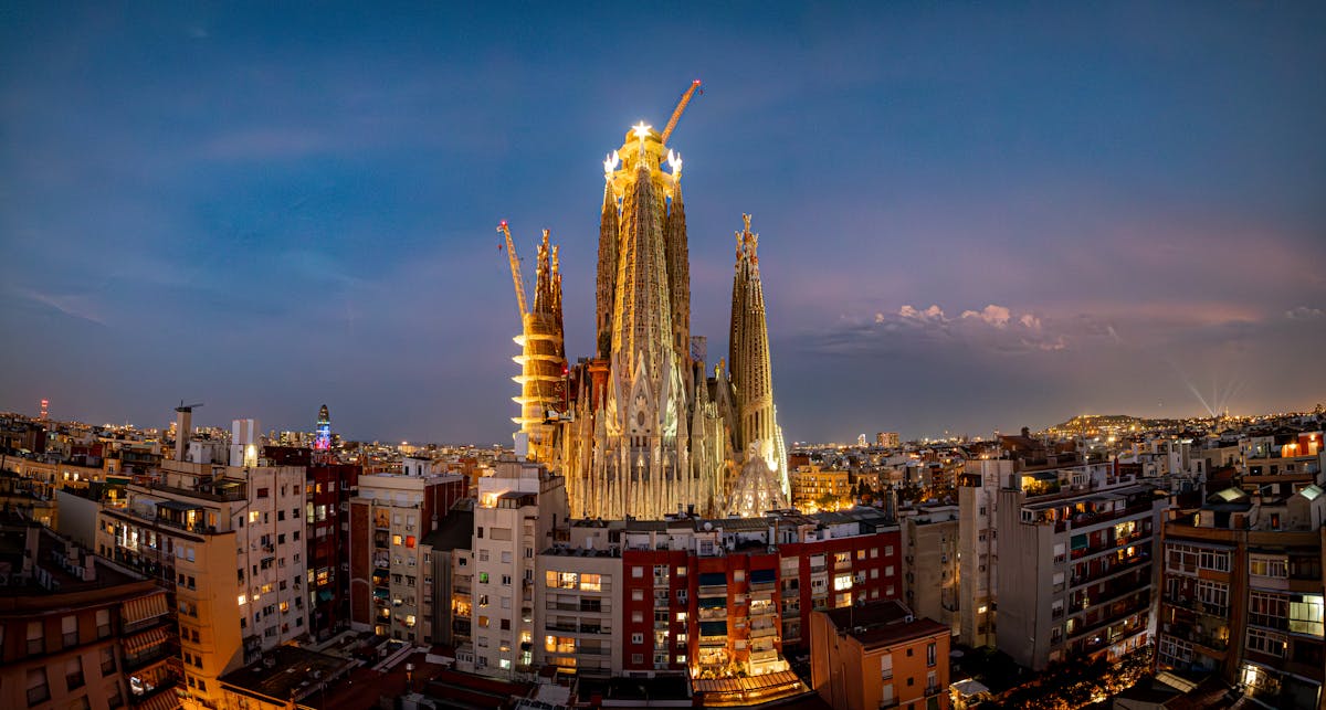 Sagrada Familia illuminated at twilight against the Barcelona cityscape