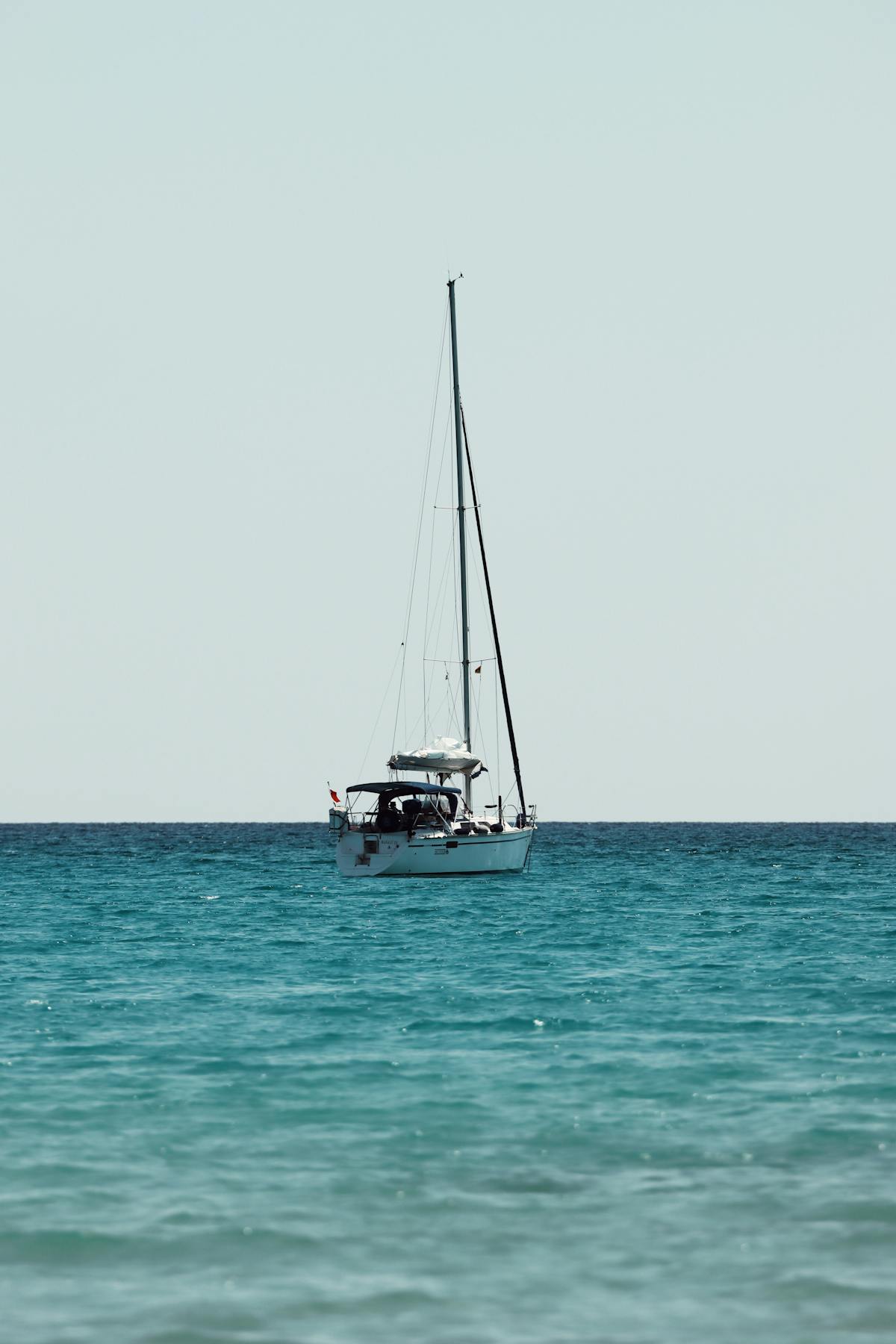 A sailboat on the azure blue sea near the coast of Cagliari Sardinia