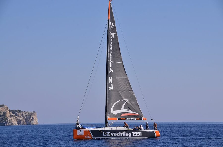 Sailboat gliding over deep blue sea under clear sky