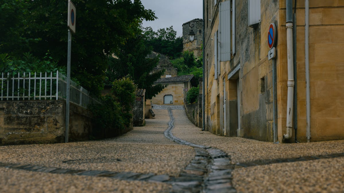 Sunlit cobblestone street with traditional stone architecture in Saint-Emilion during summer