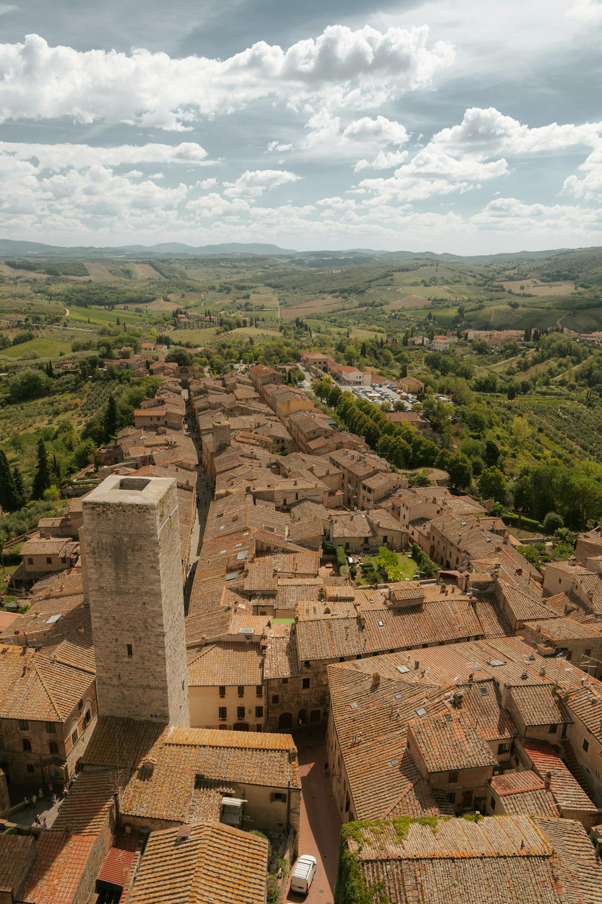 Aerial view of San Gimignano surrounded by rolling Tuscan farmland and hills