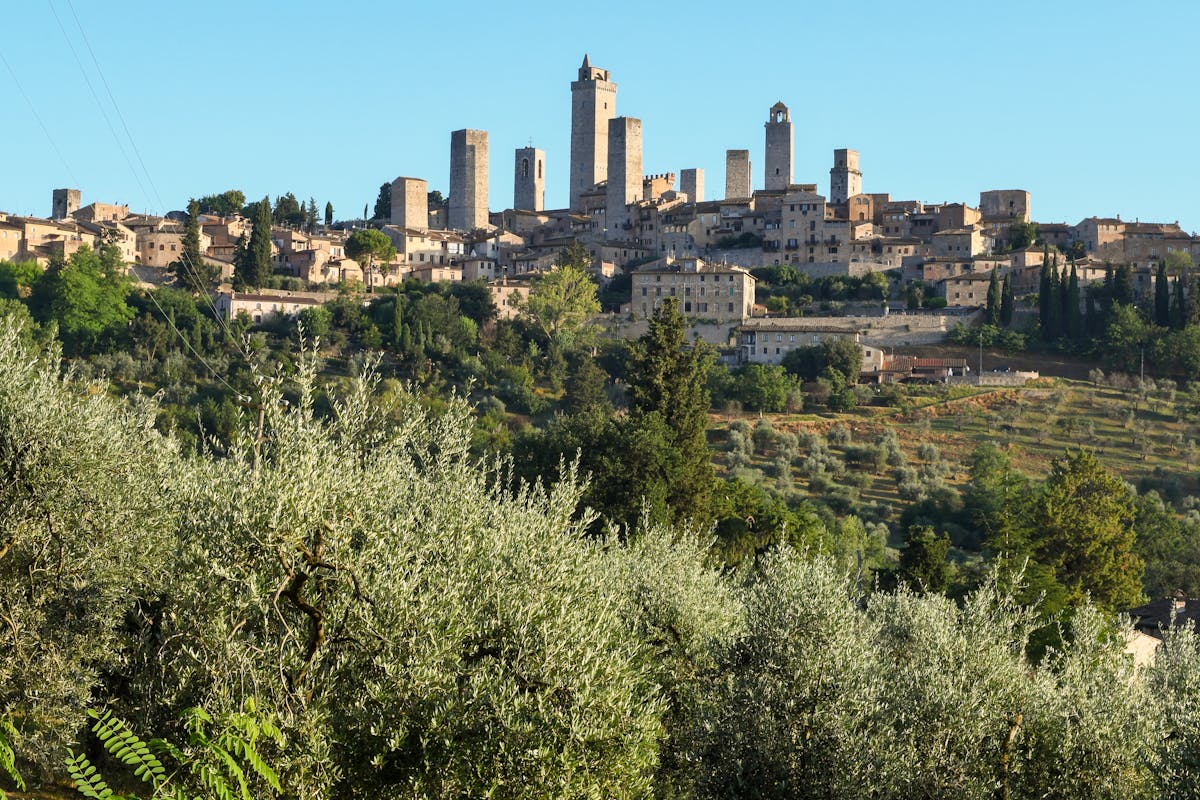 The medieval towers of San Gimignano rising above the Tuscan hills against a dramatic sky