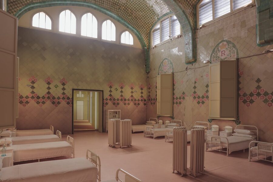Interior of a historical hospital ward at Sant Pau with ornate tiled walls and arches