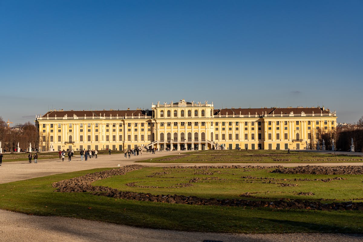 Schonbrunn Palace facade against a bright blue sky on a clear day