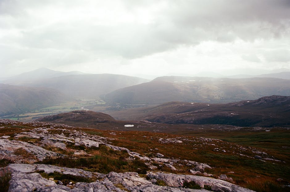 Sweeping view of the Scottish Highlands with rugged terrain and moody skies