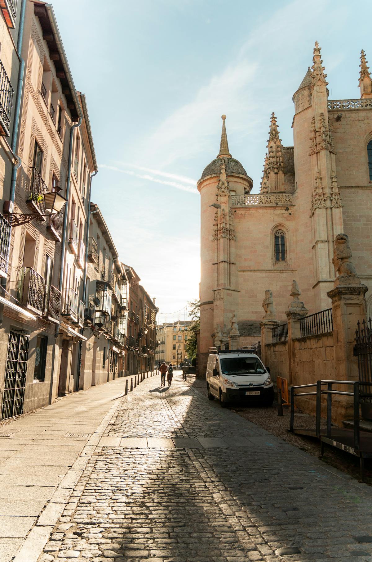 A charming street in Segovia's old town with stone buildings and warm light