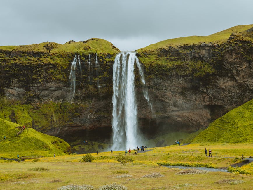 Seljalandsfoss waterfall surrounded by green cliffs Iceland