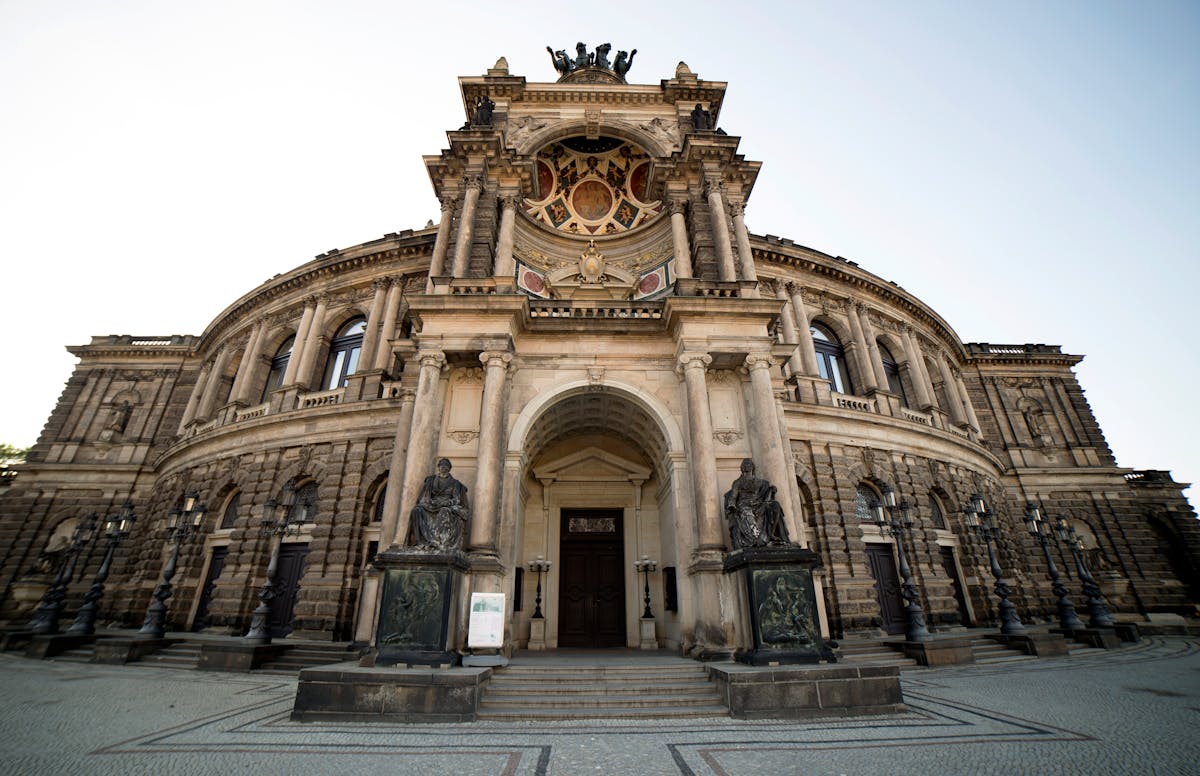 The ornate Neo-Renaissance entrance of the Semperoper in Dresden with detailed stone carvings and columns