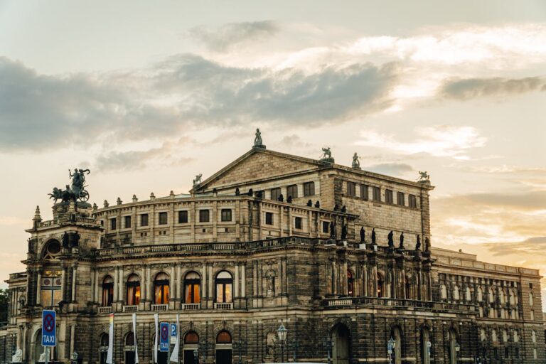 The Semperoper opera house in Dresden bathed in warm sunset light with the Theaterplatz in the foreground