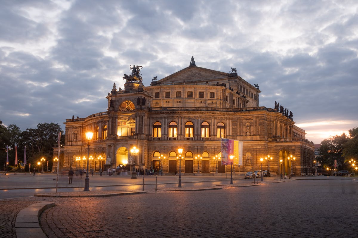 The Semperoper opera house illuminated at twilight against a deep blue Dresden sky