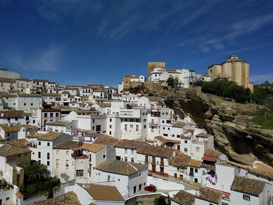 Visitors walking through Setenil de las Bodegas under rock overhang