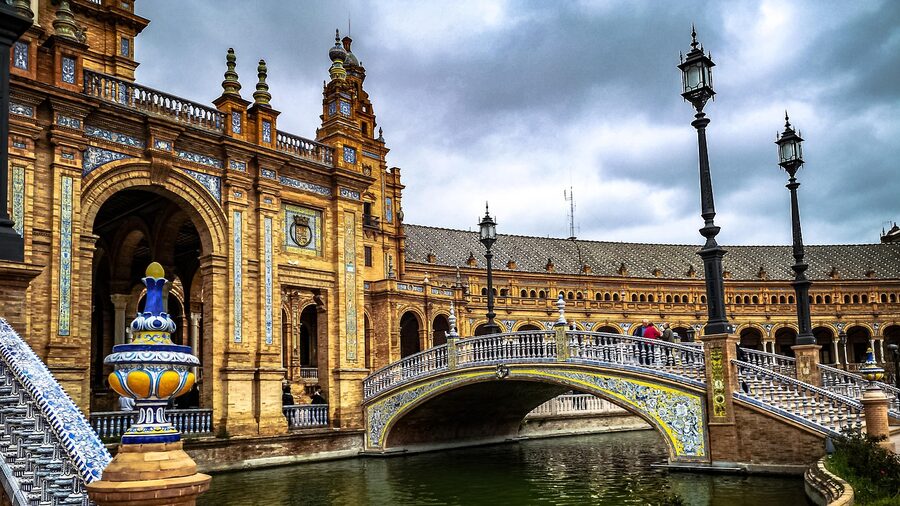 A plaza in Seville with a decorative fountain surrounded by Andalusian architecture