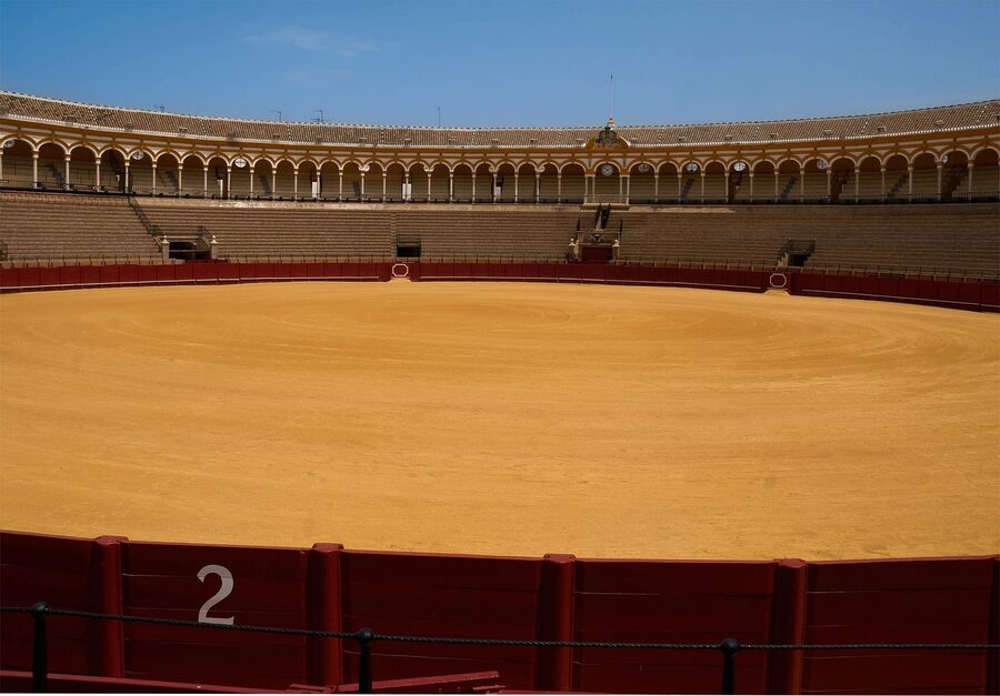 Interior of the Seville bullring arena showing the sandy ring and tiered seating