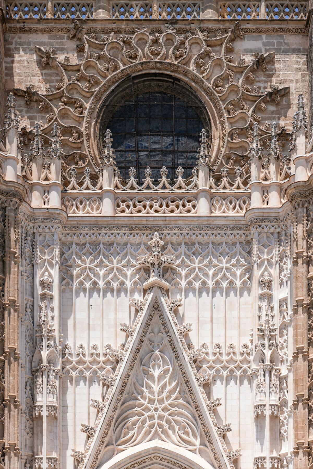 Massive stone columns inside Seville Cathedral stretching upward toward the Gothic ceiling