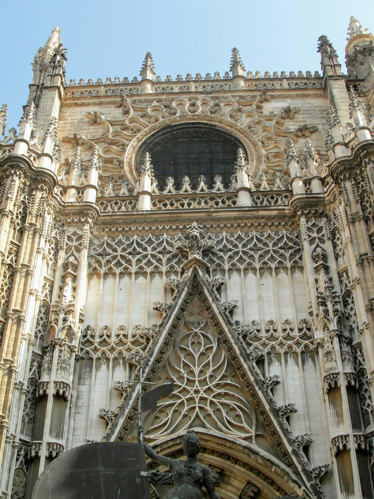 Colorful stained glass window inside Seville Cathedral casting colored light on the stone walls