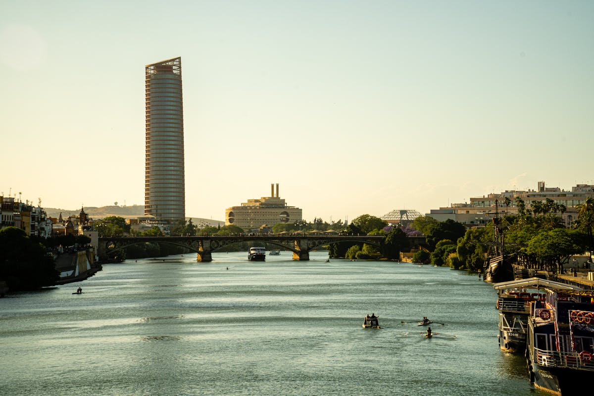 Guadalquivir River and Seville city skyline at sunset with modern bridges