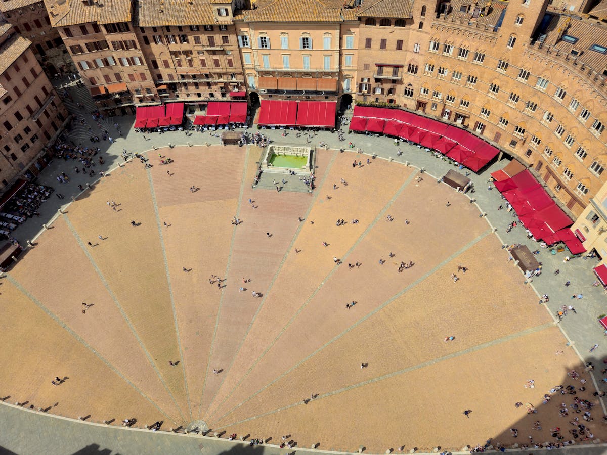 The shell-shaped Piazza del Campo in Siena surrounded by medieval buildings and the Torre del Mangia