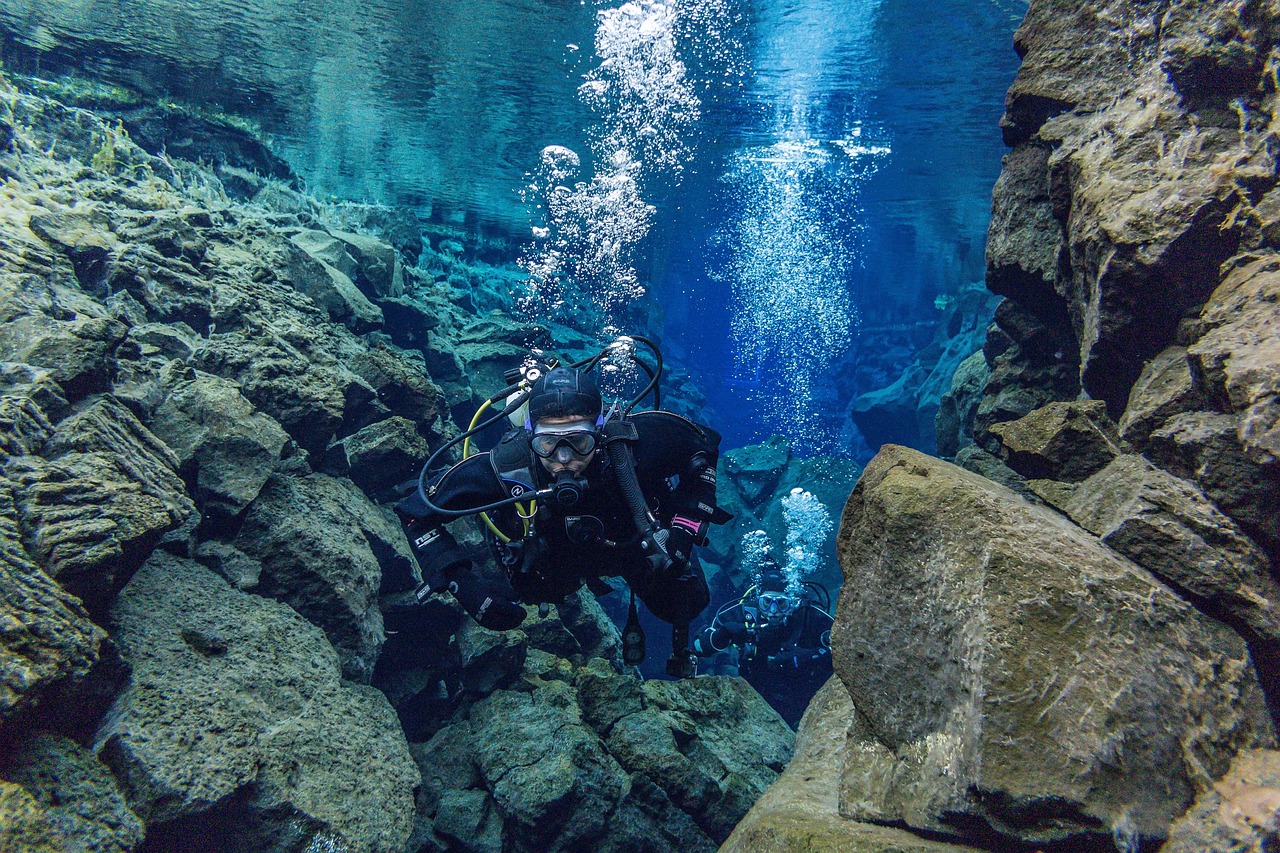 Crystal clear blue water in Silfra fissure showing rock formations and tectonic plate walls underwater