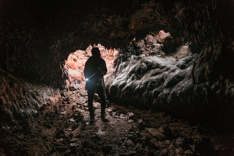 Silhouette of cave explorer with flashlight