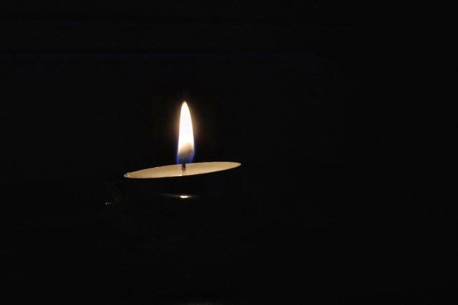 Single candle flame in darkness