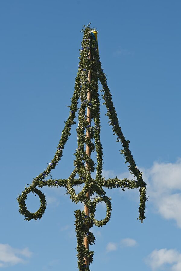Skansen Midsommar maypole decorated with flowers and crowns