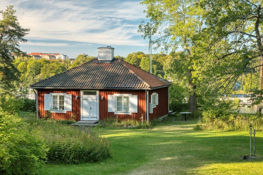 Red cottage at Skansen surrounded by green Stockholm summer landscape