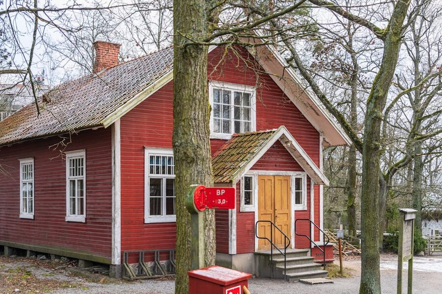 Skansen red wooden house in snow with traditional Swedish architecture
