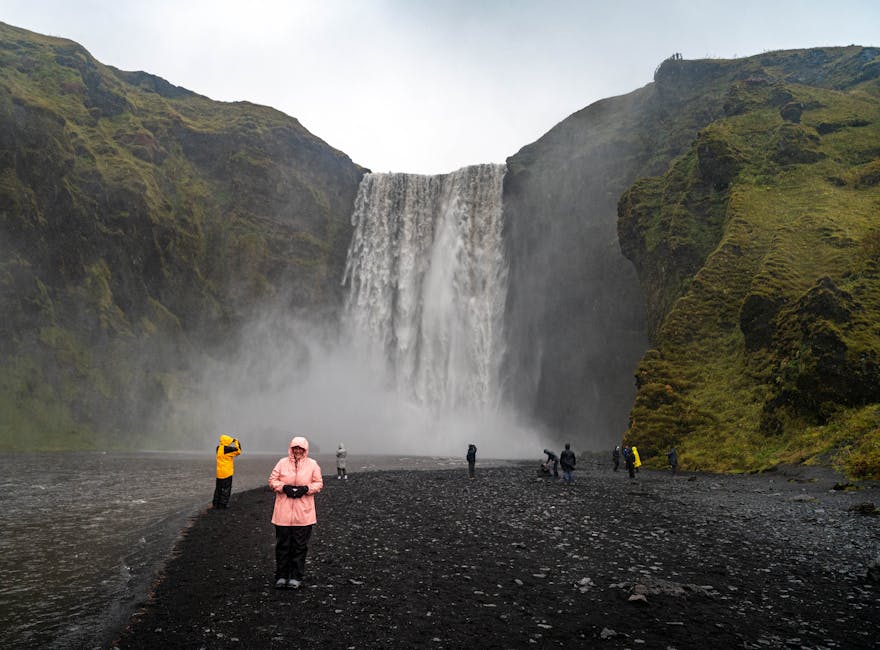 Tourists at the foot of Skogafoss waterfall