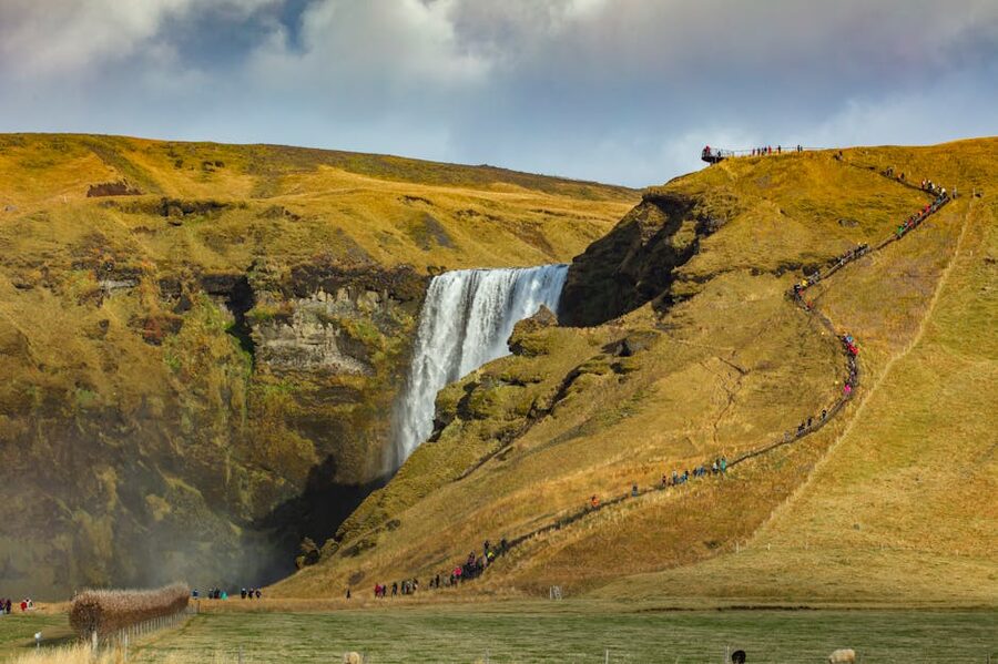 Skogafoss waterfall with hikers Iceland scale