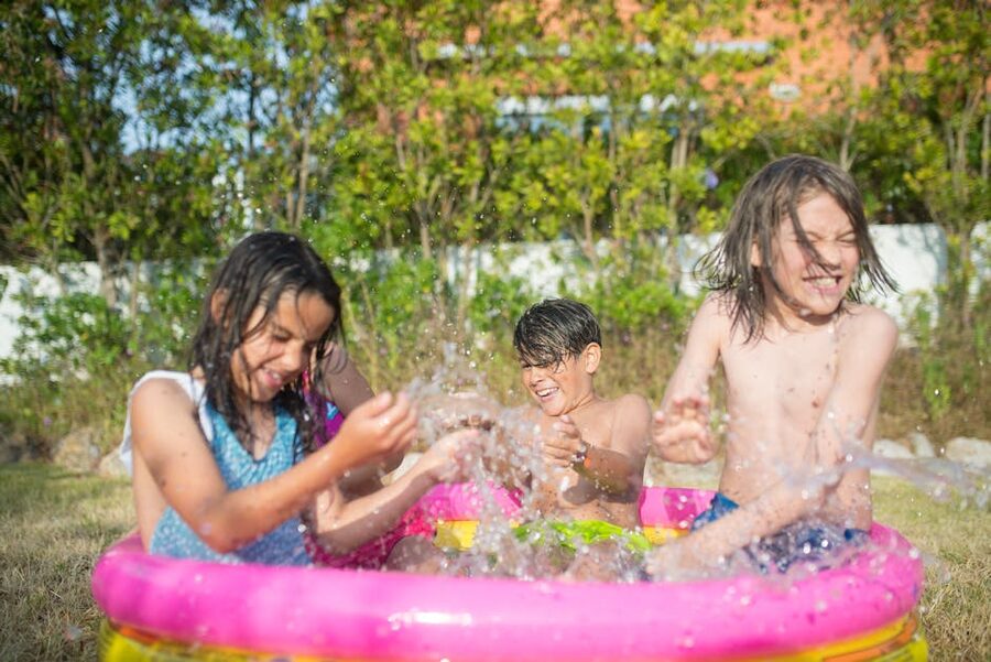 Children splashing in an outdoor pool on a sunny day