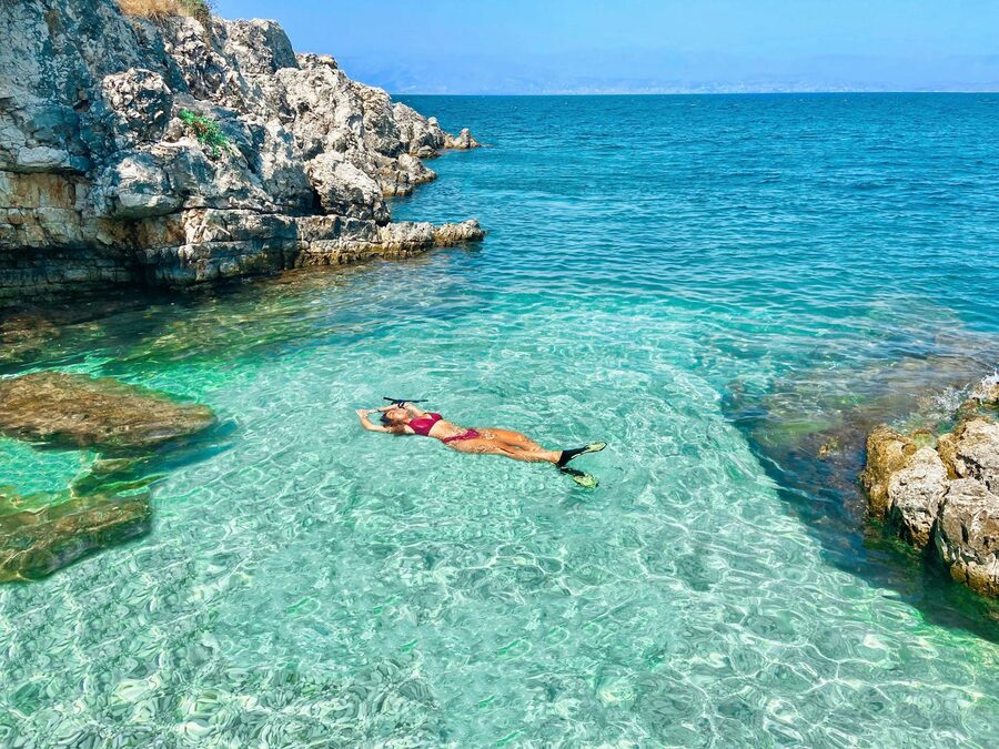 Snorkeler exploring clear rocky waters in the Mediterranean