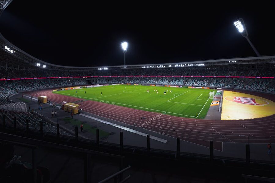 Empty soccer stadium at night under spotlights