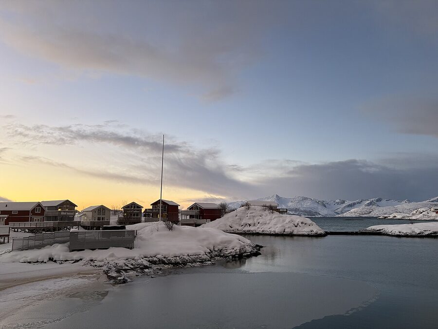 Sommaroy red rorbuer cabins with Senja in the background