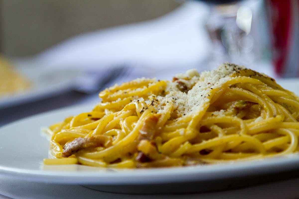 Close-up of spaghetti carbonara with grated Parmesan cheese