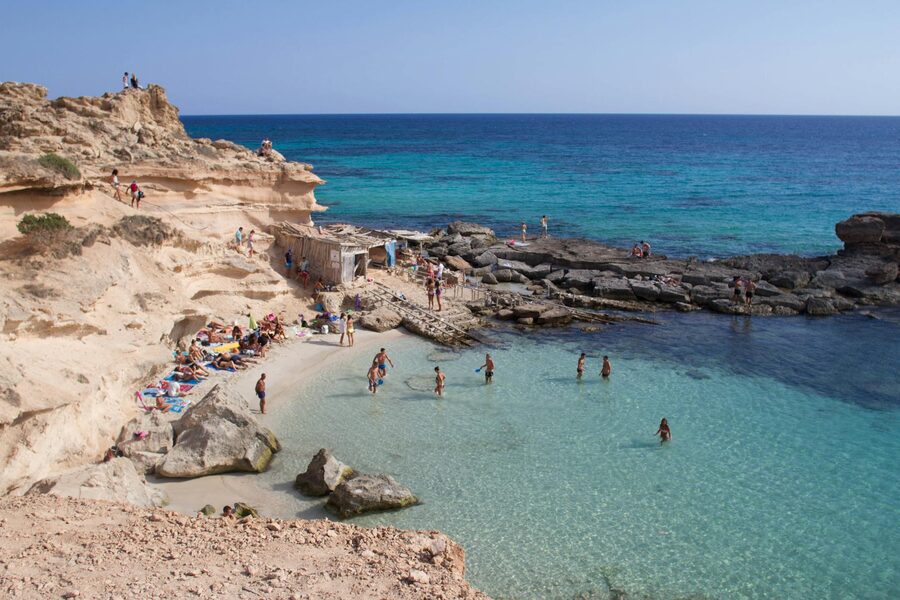 People enjoying a rocky beach cove with clear water on the Spanish coast
