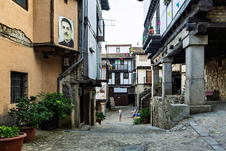 Cobblestone pathway with rustic stone buildings in a traditional Spanish village