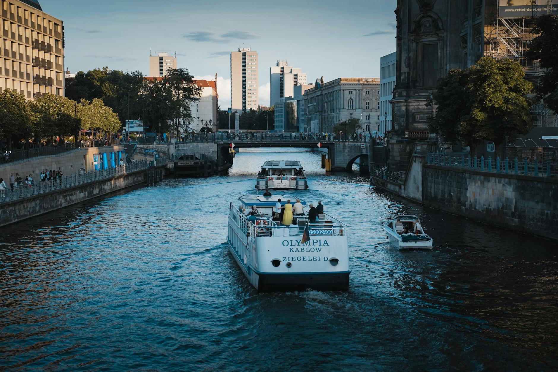 A canal in Berlin lined with moored boats and modern apartment buildings