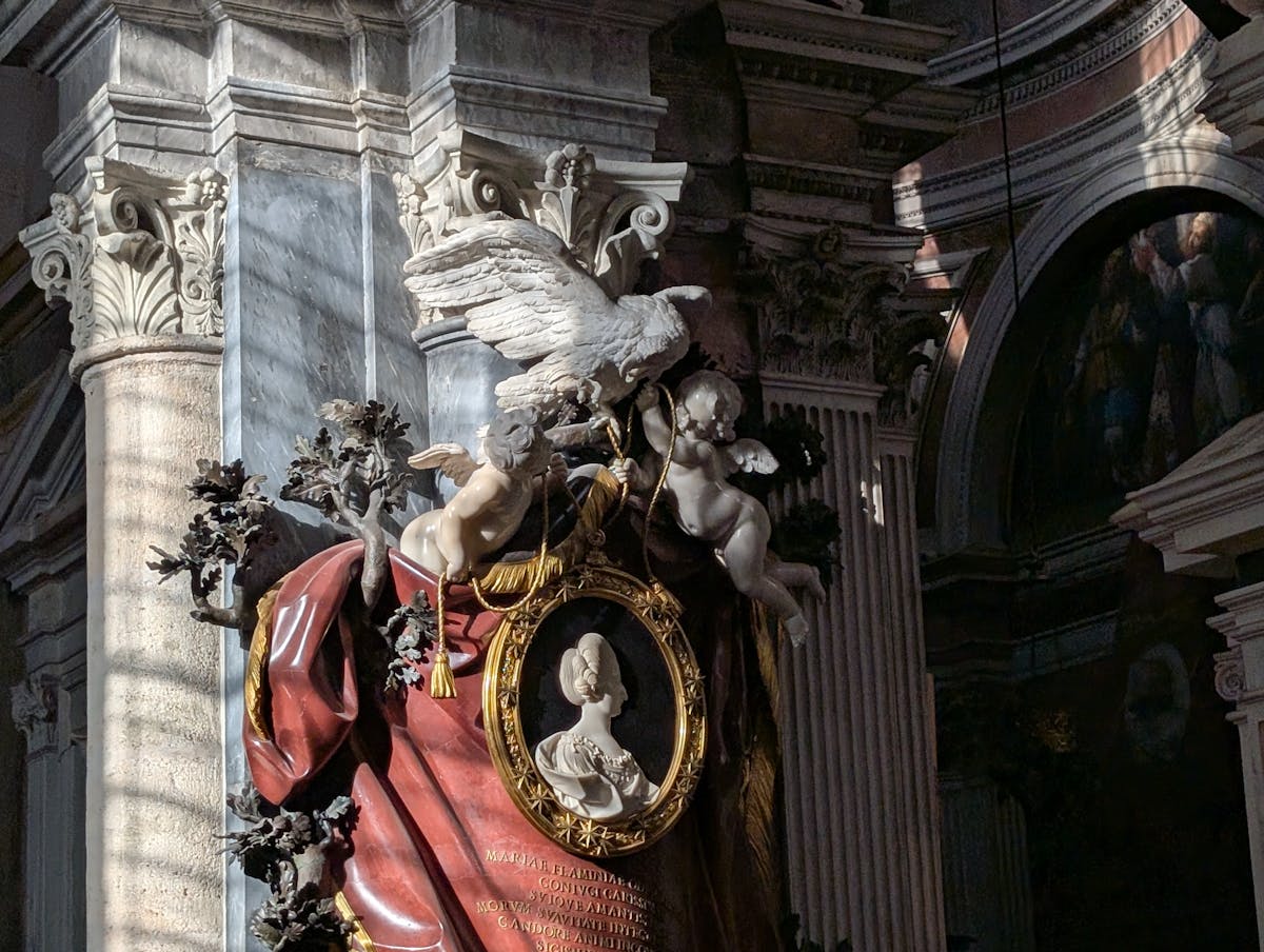 Ornate Baroque angel sculpture with dramatic lighting inside an Italian church