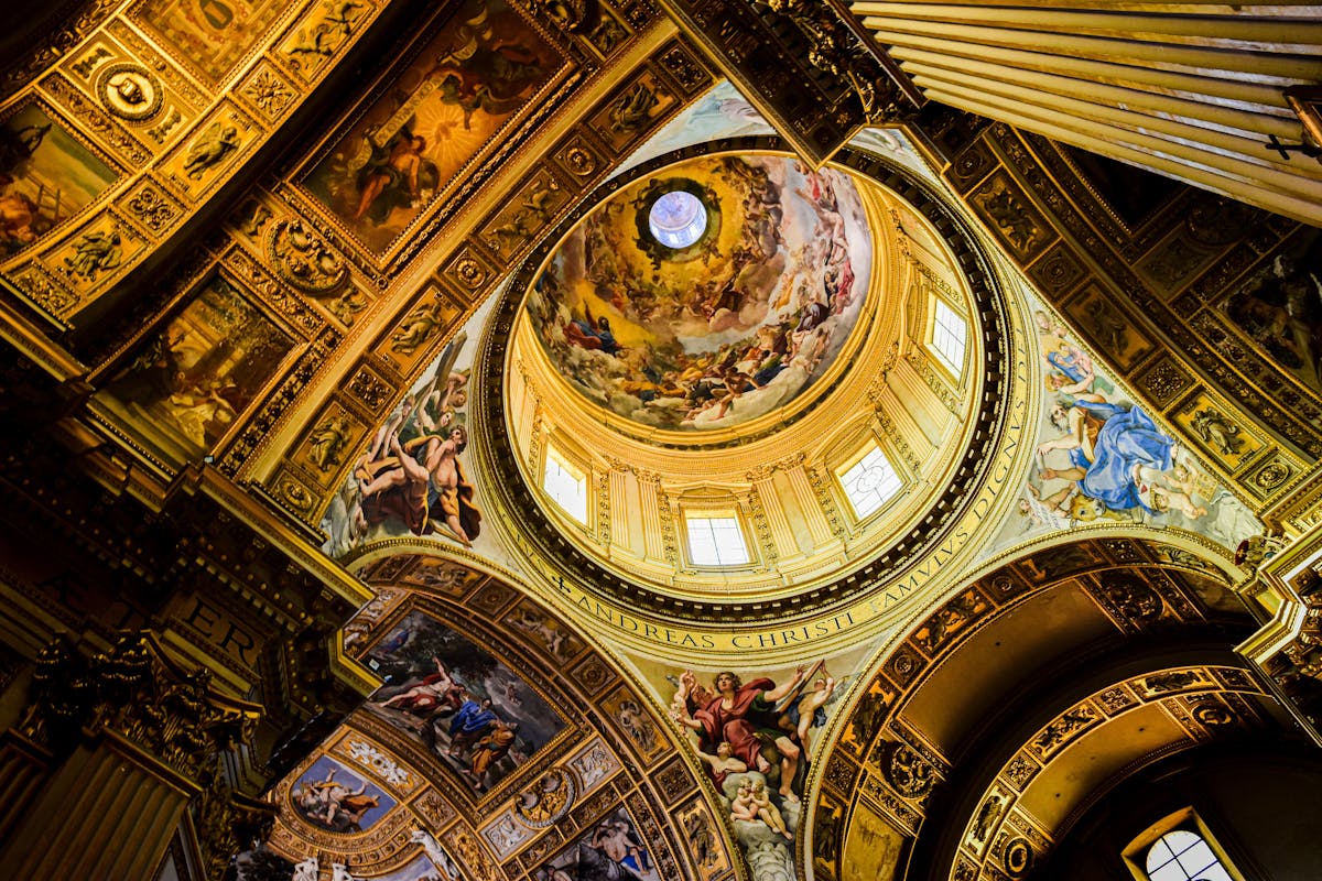 The ceiling frescoes inside St. Peters Basilica dome showing religious figures and golden decorations