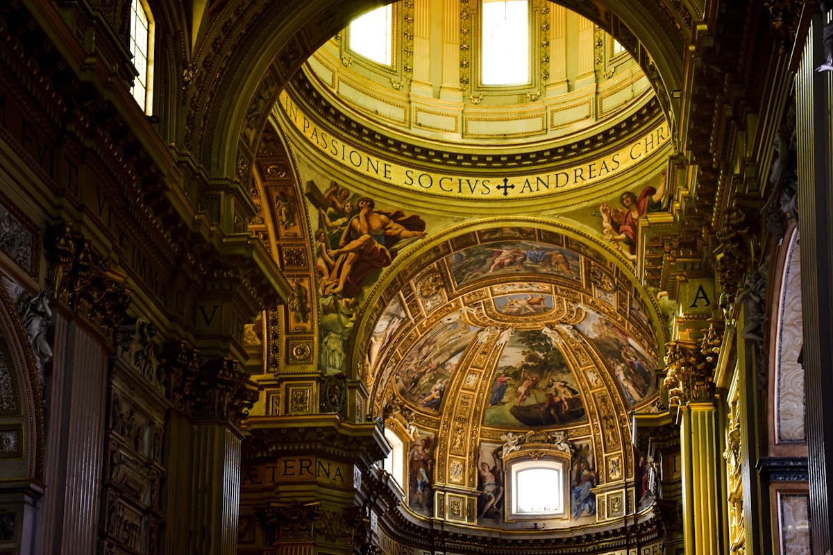The richly decorated interior of a basilica dome showing religious frescoes and golden details