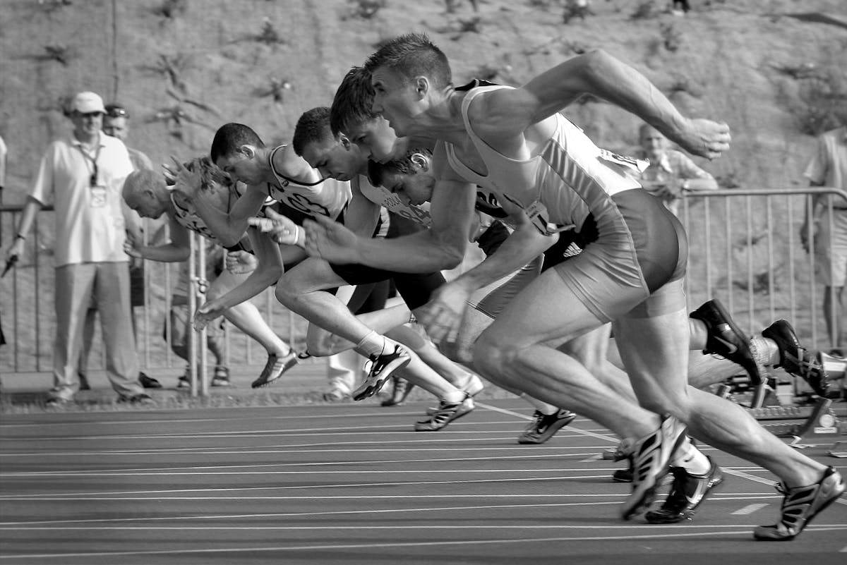 Athletes sprinting from starting blocks on running track
