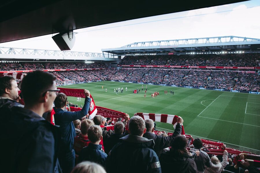 Football supporters cheering as players take the field at a stadium