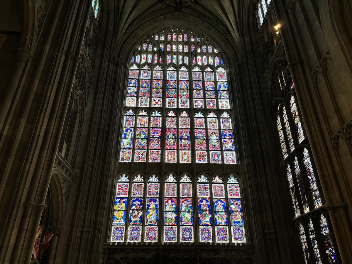 Detailed stained glass window with vivid colours inside a Gothic cathedral