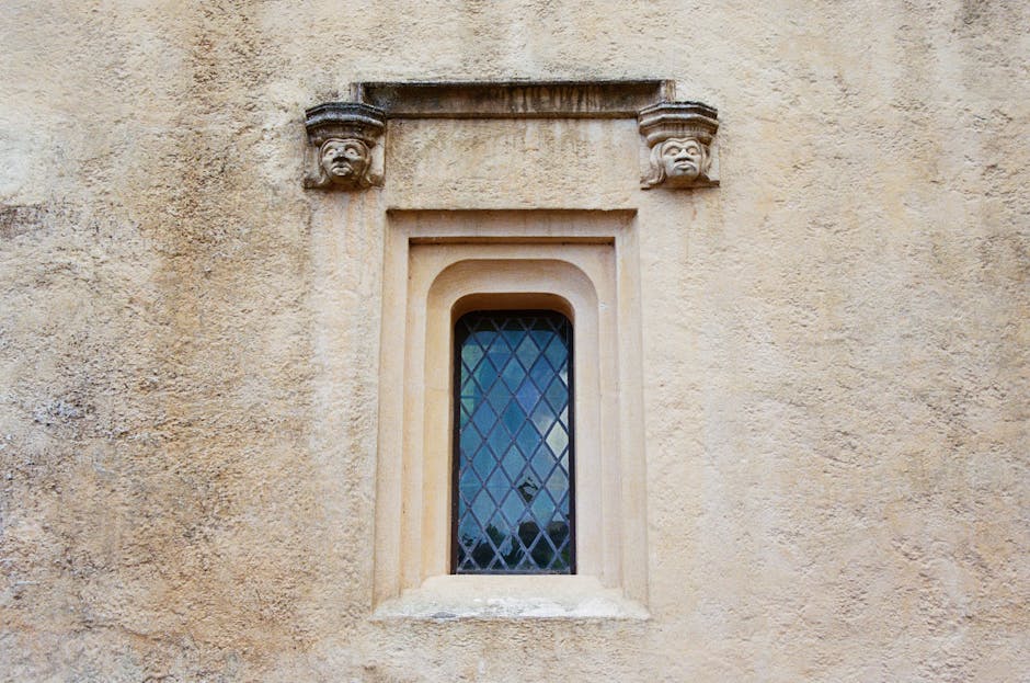 Close-up of carved stone faces on a historic window at Stirling Castle Scotland