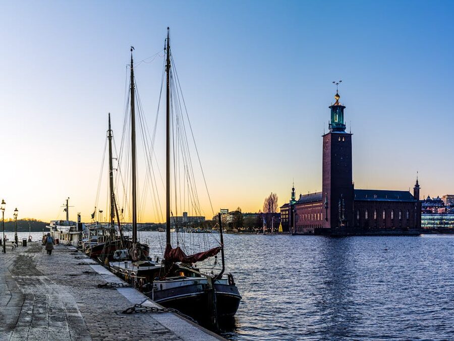 Stockholm City Hall with sailing boats at sunset